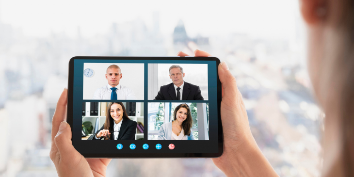 A man is having a video call with coworkers.