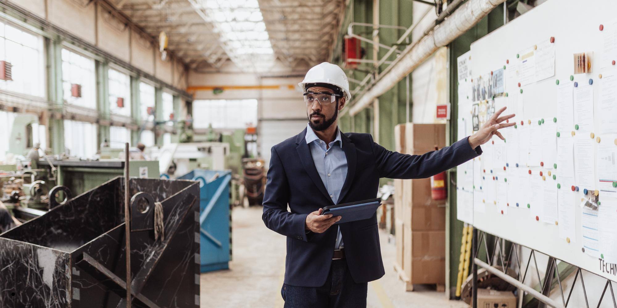 A young man showing safety scoreboard at a workplace.