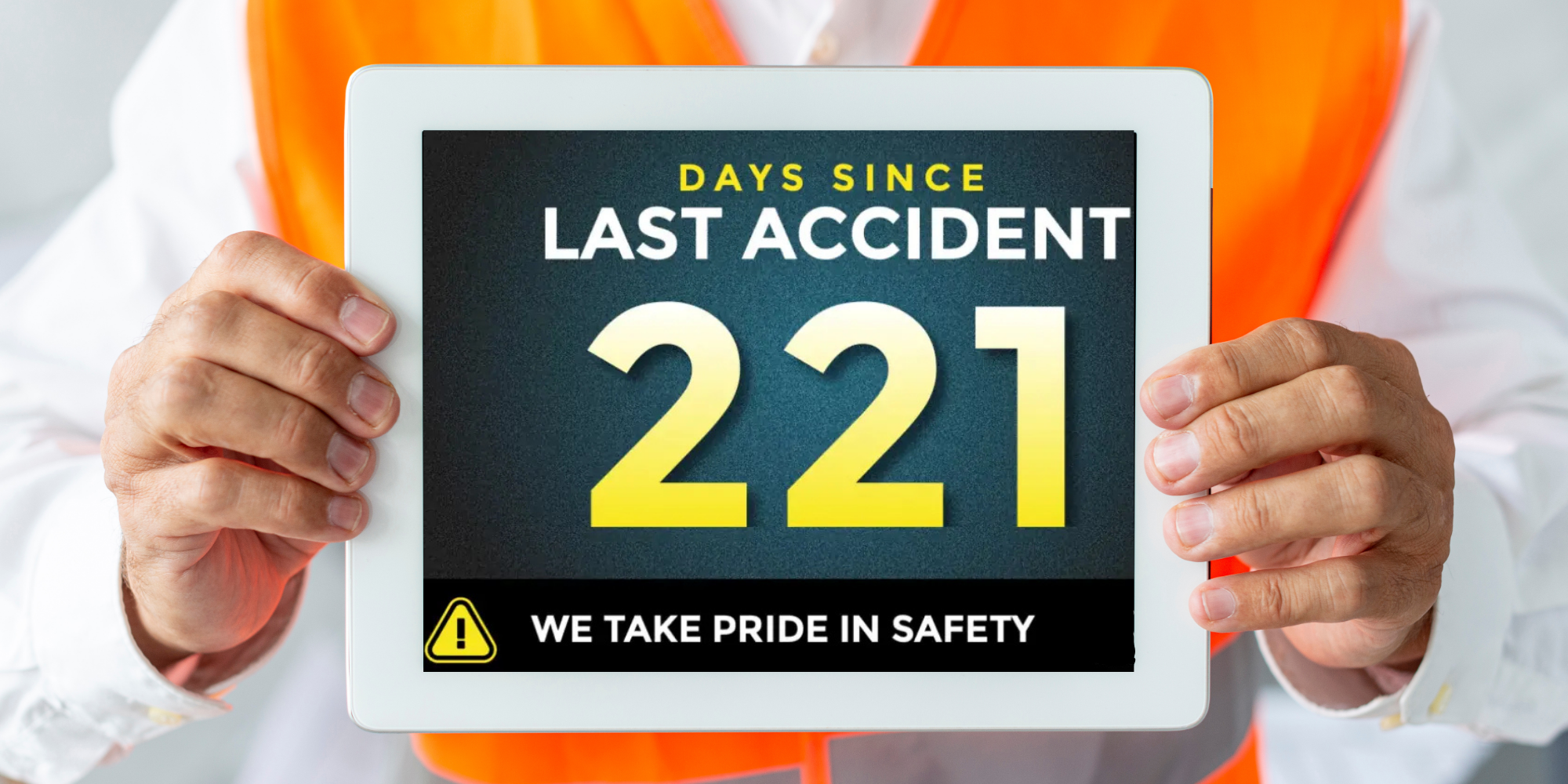 A man smiling and holding a "Days Without Accident" digital sign.