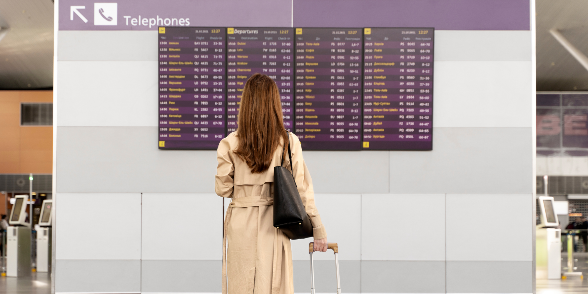 A woman looking at the Digital Board in Airport.